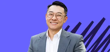 A young man in an office attire on a blue background.