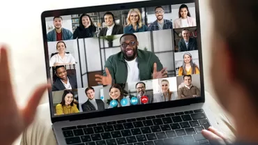 Person in Videokonferenz auf einem Laptop.