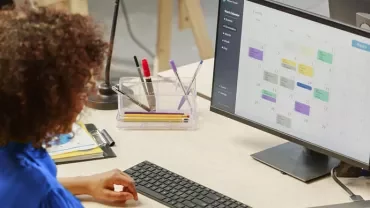 Person betrachtet einen Kalender auf einem Computermonitor.