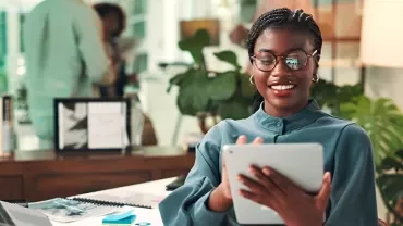 Frau im Büro arbeitet am Tablet.