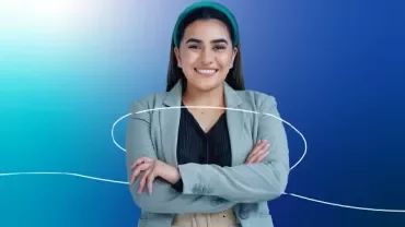 A lady in an office attire smiling on a blue gradient background.