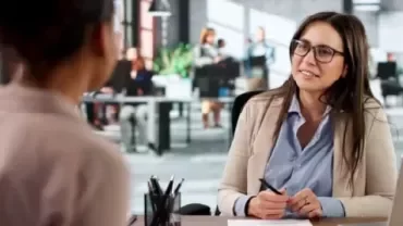 Zwei Frauen führen in einem modernen Büro ein professionelles Bewerbungsgespräch.