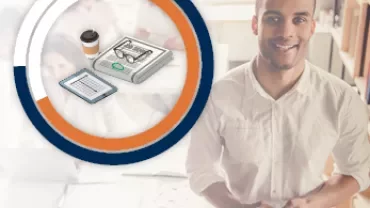Mann mit Telefon, Kaffee und Tablet, sitzt vor einem Schreibtisch und Diagramm.