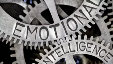 Nahaufnahme von Zahnrädern mit den Worten 'Emotional Intelligence'.