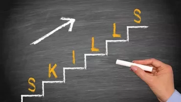 Treppe mit Wort 'Skills' und Pfeil an Tafel.