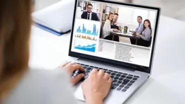 Videokonferenz auf Laptop mit Diagrammen und Besprechung.