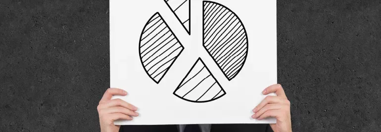 Person hält ein Poster mit handgezeichnetem Kuchendiagramm vor dem Gesicht.