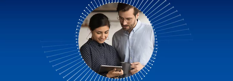 Zwei Personen nutzen ein Tablet und lächeln.
