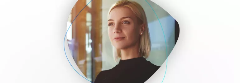 Porträt einer lächelnden Frau mit blondem Haar in einem hellen Raum.