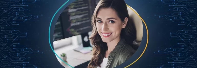 Frau lächelt vor einem Computerbildschirm mit Code