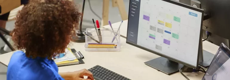 Person betrachtet einen Kalender auf einem Computermonitor.