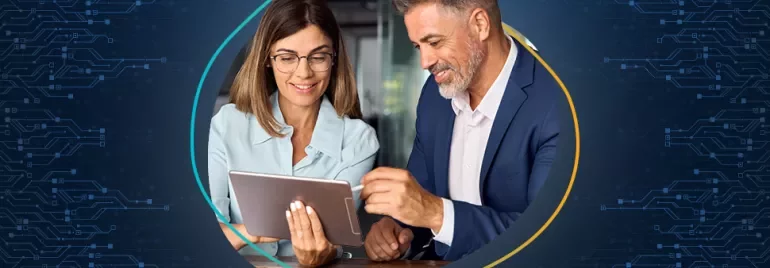 Zwei Menschen betrachten ein Tablet in einem Büro.
