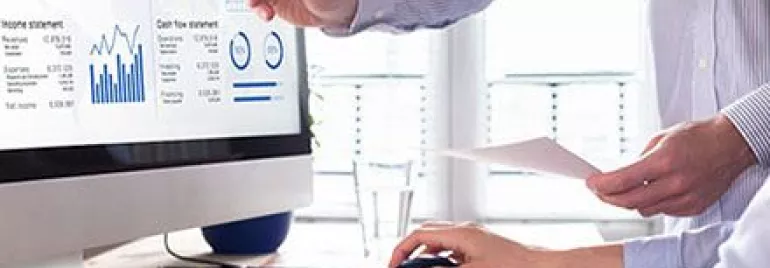 Zwei Personen diskutieren Daten auf einem Monitor.