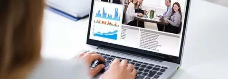 Videokonferenz auf Laptop mit Diagrammen und Besprechung.