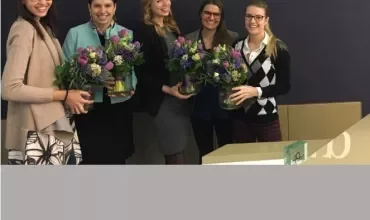 Fünf Frauen halten Blumensträuße bei Page Group.