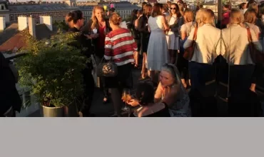 Menschen genießen eine Dachterrassenparty bei Sonnenuntergang.