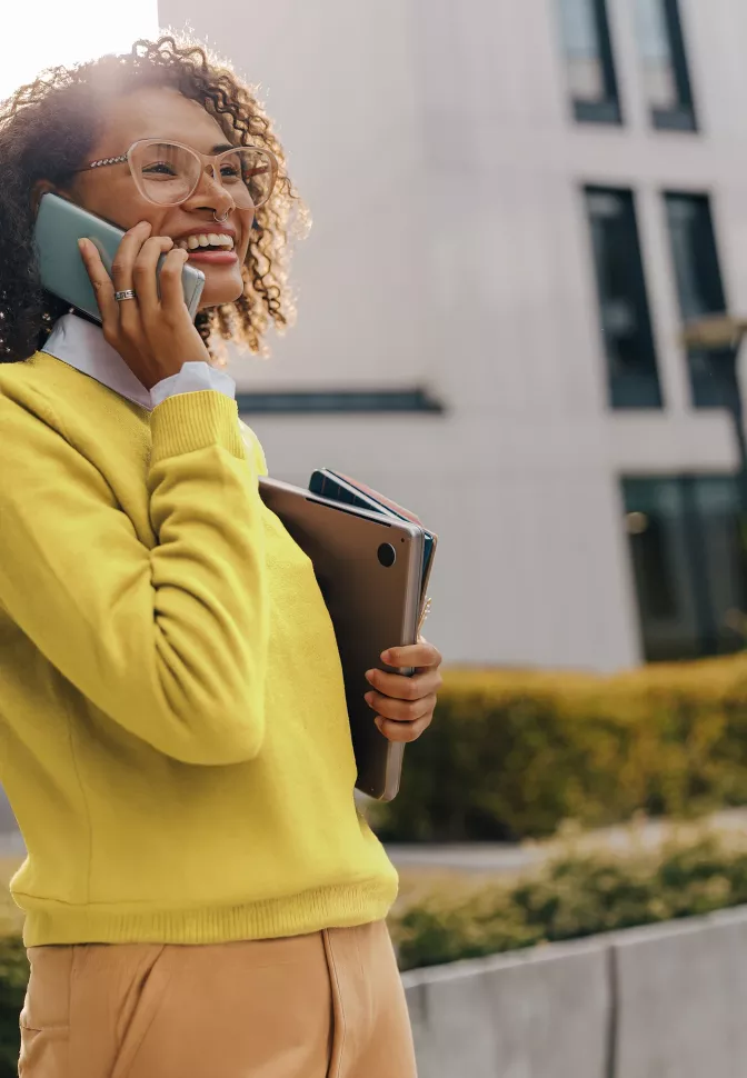 A woman in a yellow shirt making a call.