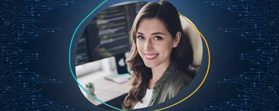 Frau lächelt vor einem Computerbildschirm mit Code