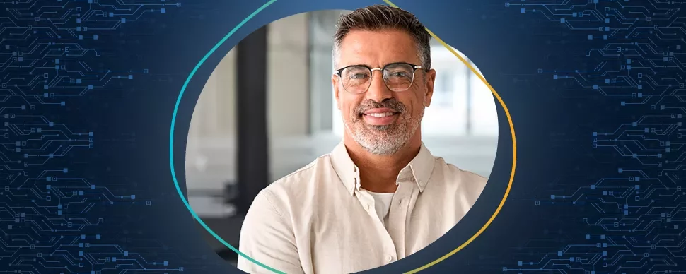 Porträt eines lächelnden Mannes mit Brille vor einem technischen Hintergrund.