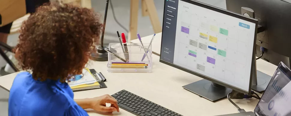 Person betrachtet einen Kalender auf einem Computermonitor.
