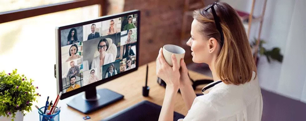Eine Frau arbeitet im Homeoffice und hat eine Telefonkonferenz mit ihrem Team.