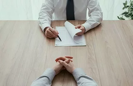 Personen bei einem Bewerbungsgespräch am Tisch.